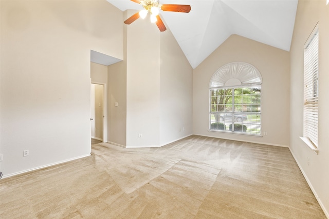 carpeted spare room featuring ceiling fan and high vaulted ceiling