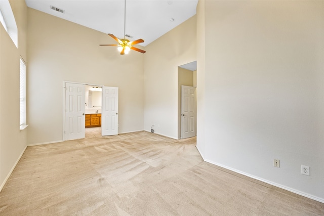 unfurnished living room featuring light colored carpet, high vaulted ceiling, and ceiling fan