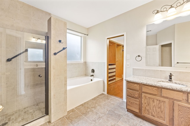 bathroom featuring tile patterned flooring, vanity, and shower with separate bathtub