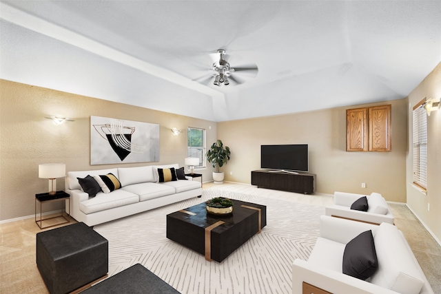 carpeted living room with a tray ceiling and ceiling fan