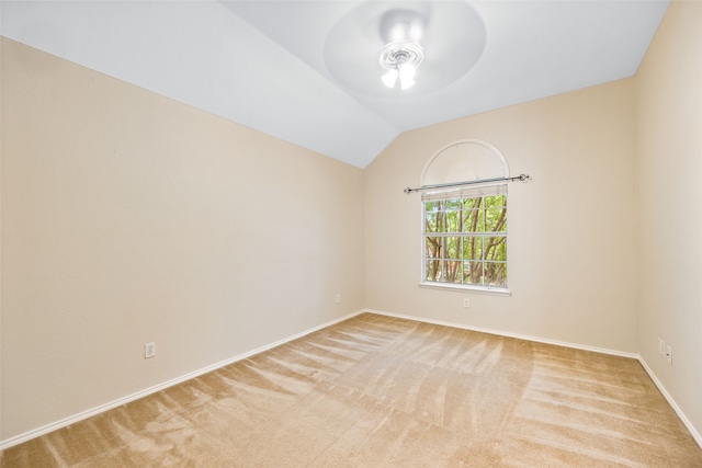 carpeted spare room with ceiling fan and vaulted ceiling