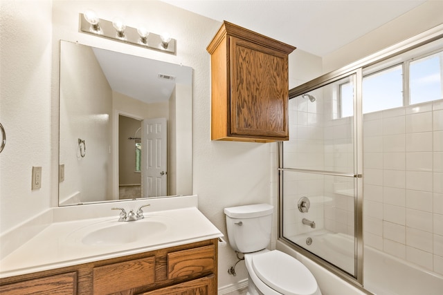 full bathroom with shower / bath combination with glass door, vanity, and toilet