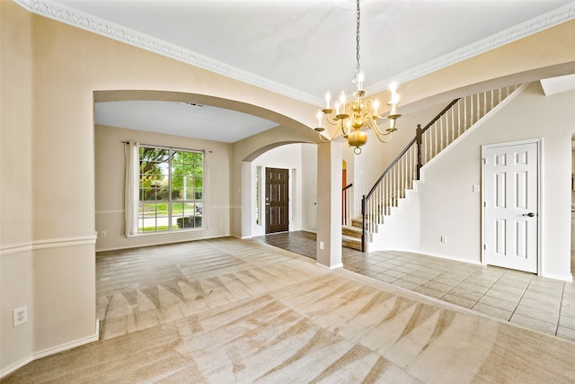 carpeted empty room featuring a notable chandelier and ornamental molding