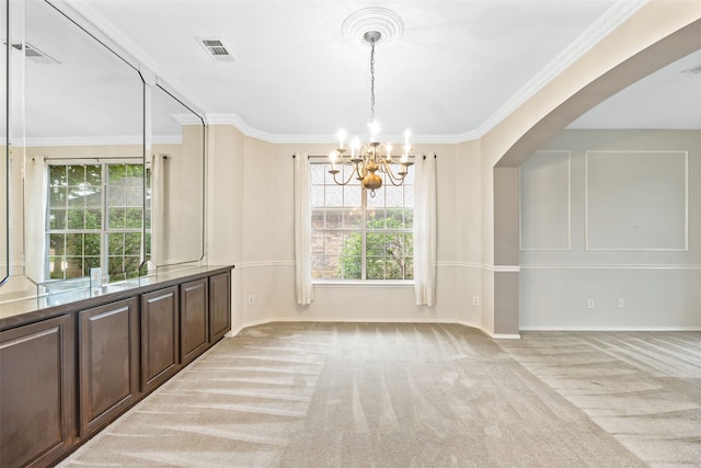 carpeted empty room with ornamental molding and a chandelier