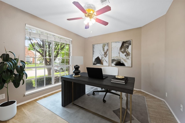 carpeted home office featuring ceiling fan