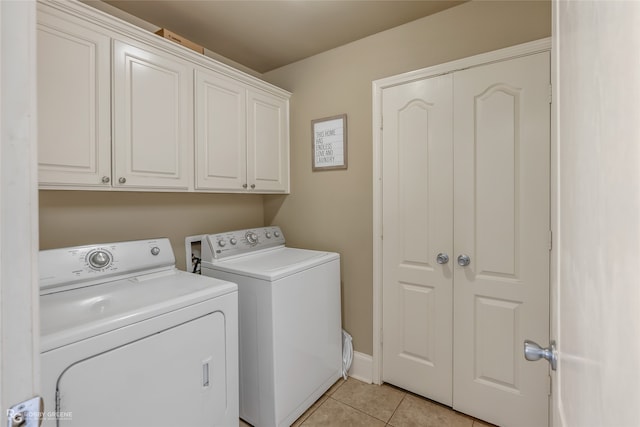 washroom featuring light tile patterned floors, washing machine and clothes dryer, and cabinets