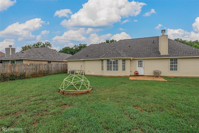 back of property with a lawn and a patio area