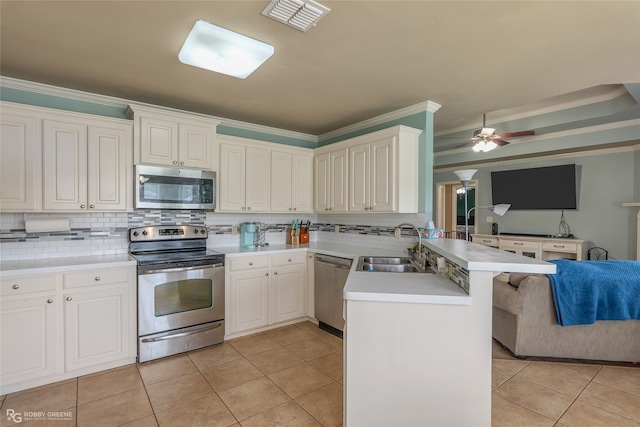 kitchen featuring a kitchen breakfast bar, appliances with stainless steel finishes, crown molding, kitchen peninsula, and ceiling fan