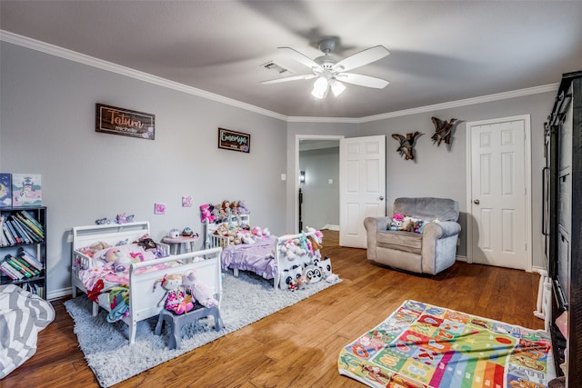 bedroom featuring crown molding, wood-type flooring, and ceiling fan