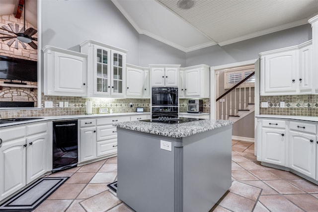 kitchen featuring white cabinetry, tasteful backsplash, a center island, and vaulted ceiling with beams