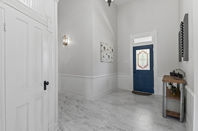 1401 Arp St, Commerce, TX 75428 - entrance foyer with light marble finish floors, a towering ceiling, and a wainscoted wall