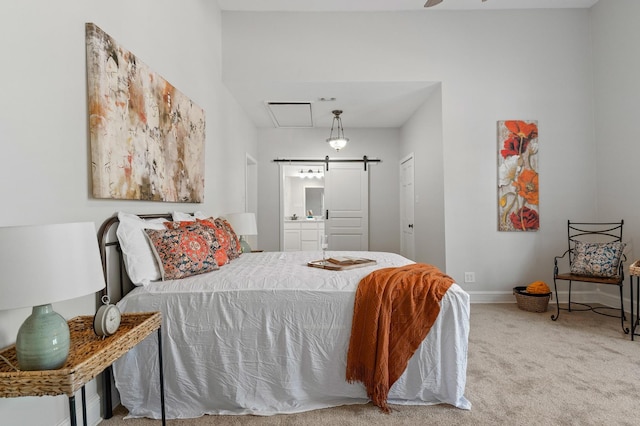 1401 Arp St, Commerce, TX 75428 - carpeted bedroom featuring a barn door, ensuite bath, and baseboards