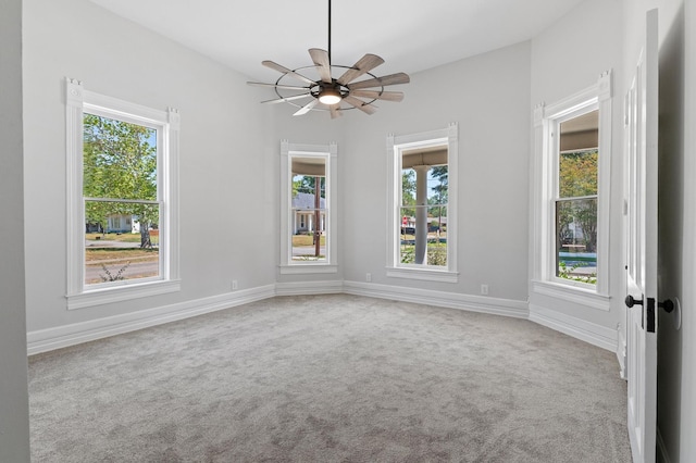 unfurnished room featuring plenty of natural light, ceiling fan, and light carpet