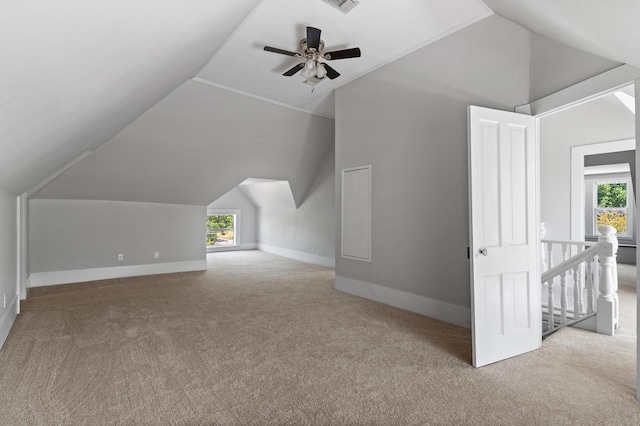 additional living space with ceiling fan, lofted ceiling, light carpet, and a wealth of natural light