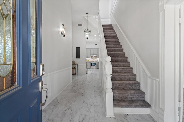 1401 Arp St, Commerce, TX 75428 - entrance foyer with a wainscoted wall, stairs, marble finish flooring, and a decorative wall