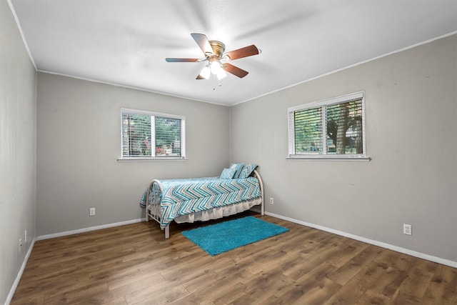 bedroom with ceiling fan, ornamental molding, hardwood / wood-style floors, and multiple windows