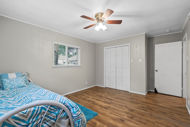 bedroom featuring crown molding, ceiling fan, a closet, and dark hardwood / wood-style flooring