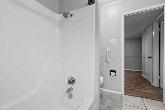 bathroom featuring toilet, hardwood / wood-style floors, and shower / bathing tub combination