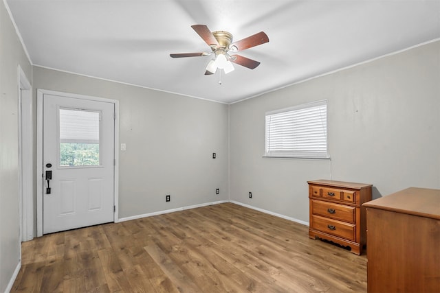 interior space featuring ceiling fan, ornamental molding, and light wood-type flooring