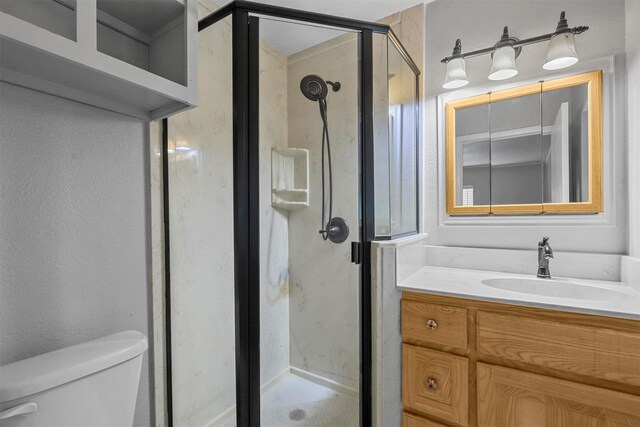 bathroom with a shower with door, vanity, and toilet