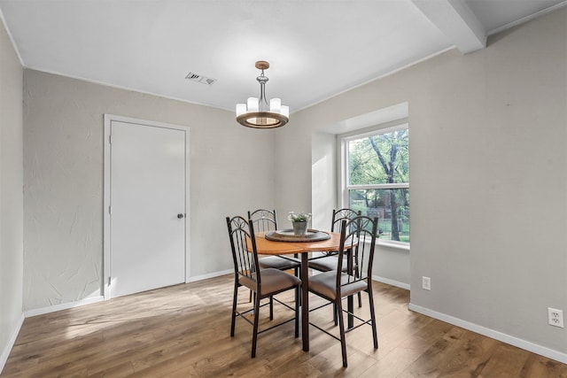 dining space with hardwood / wood-style floors and a chandelier