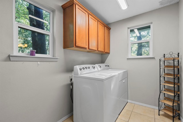 laundry room with cabinets, washer and clothes dryer, and light tile patterned flooring