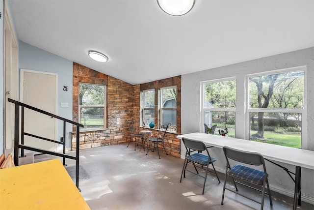 interior space with concrete floors, a healthy amount of sunlight, and vaulted ceiling