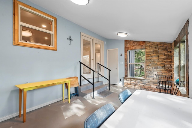 interior space featuring vaulted ceiling and concrete flooring