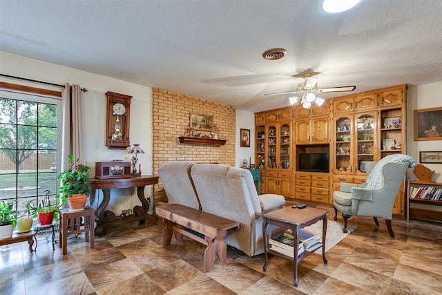 living room with ceiling fan and a textured ceiling