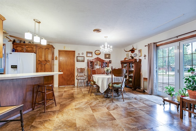 dining space featuring a textured ceiling and an inviting chandelier