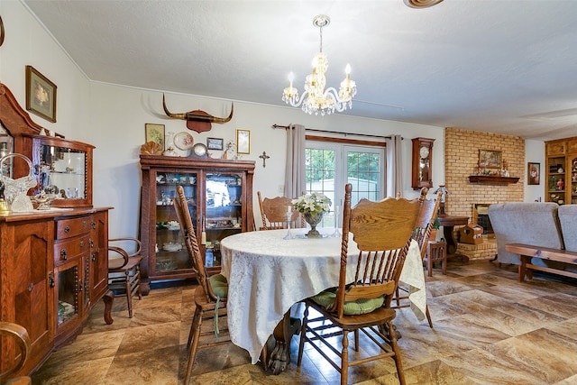 dining area with a fireplace, an inviting chandelier, and a textured ceiling