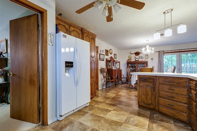 kitchen with white refrigerator with ice dispenser, a textured ceiling, ceiling fan with notable chandelier, and decorative light fixtures