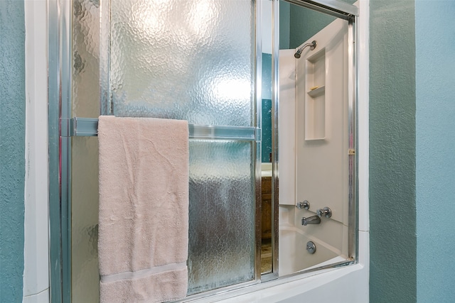 bathroom featuring bath / shower combo with glass door