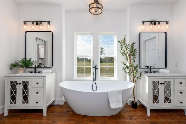 bathroom with vanity, a bath, and hardwood / wood-style floors