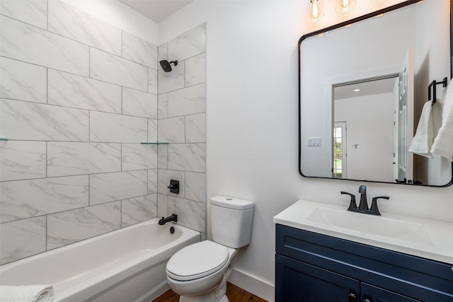 full bathroom featuring tiled shower / bath, vanity, and toilet