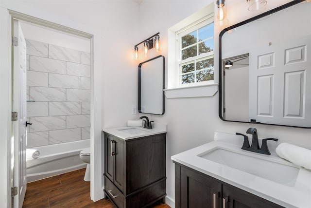 full bathroom with vanity, hardwood / wood-style floors, tiled shower / bath combo, and toilet