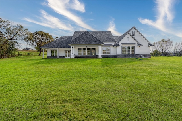 back of house featuring a yard and covered porch