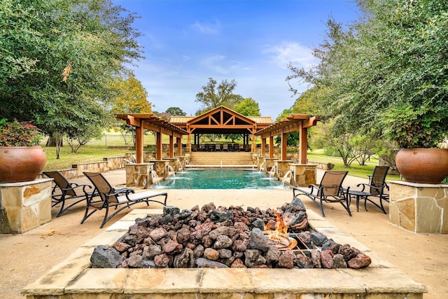 view of swimming pool featuring pool water feature, a patio, a pergola, and a fire pit