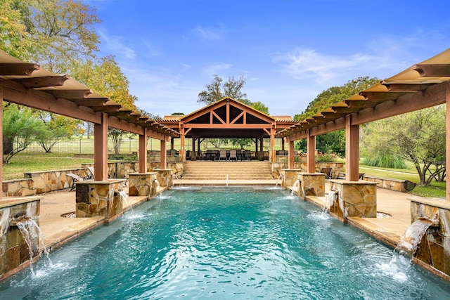 view of swimming pool with pool water feature, an outdoor bar, a patio area, and a pergola