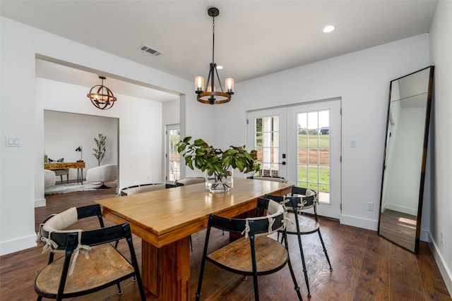 dining space with dark hardwood / wood-style flooring, french doors, and a chandelier