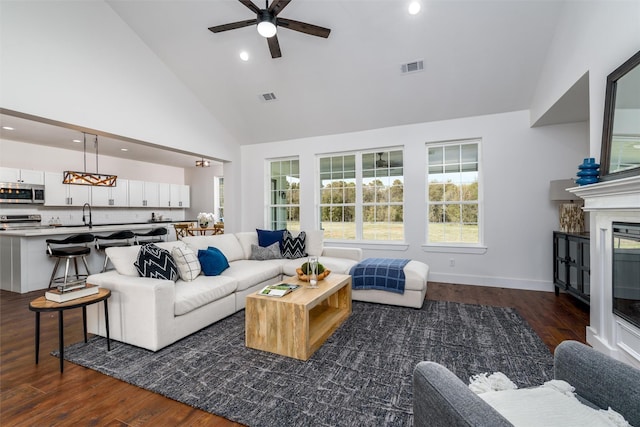 living room featuring a healthy amount of sunlight, dark hardwood / wood-style floors, and high vaulted ceiling