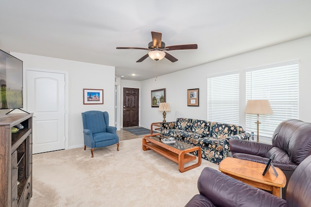 carpeted living room with ceiling fan