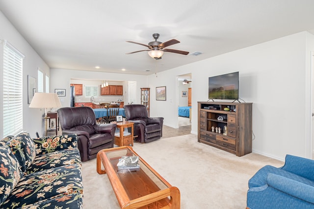 carpeted living room with ceiling fan