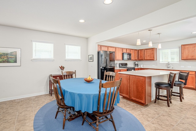 tiled dining room with a wealth of natural light and sink