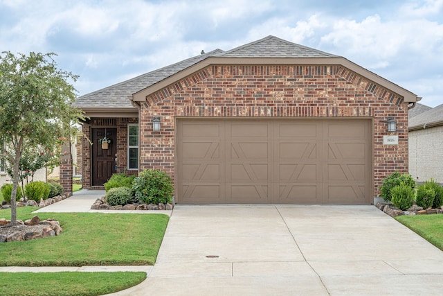 view of front of property with a garage and a front lawn