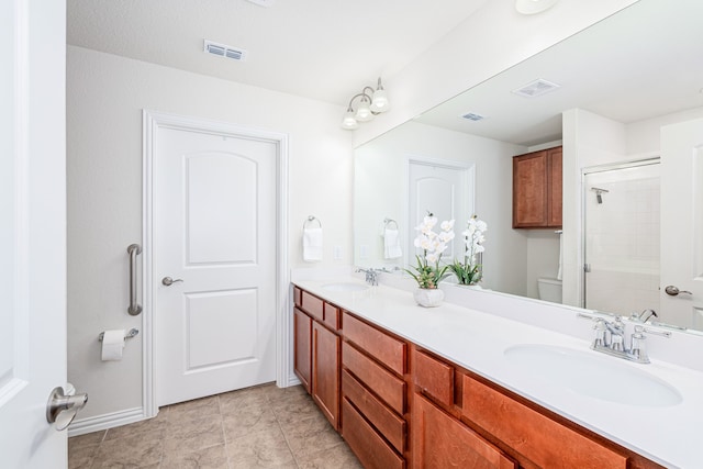 bathroom featuring vanity, a shower with shower door, tile patterned floors, and toilet