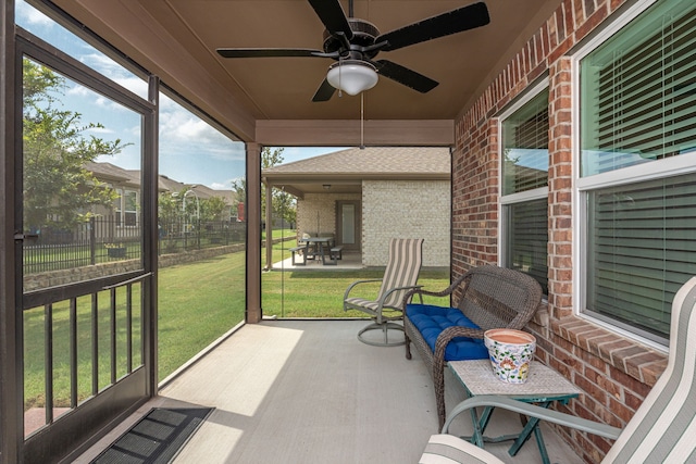 sunroom / solarium featuring a healthy amount of sunlight and ceiling fan