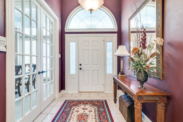 entrance foyer featuring french doors, plenty of natural light, and light tile patterned flooring