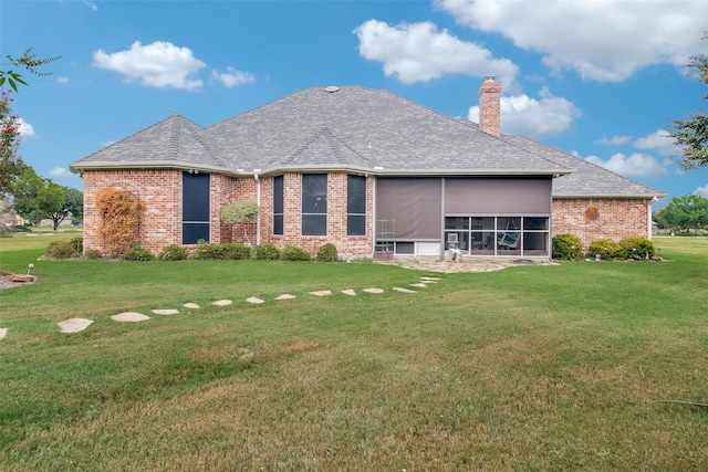 back of house featuring a yard and a sunroom