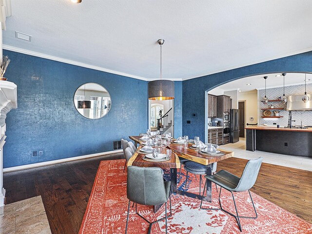 dining area with crown molding and wood-type flooring